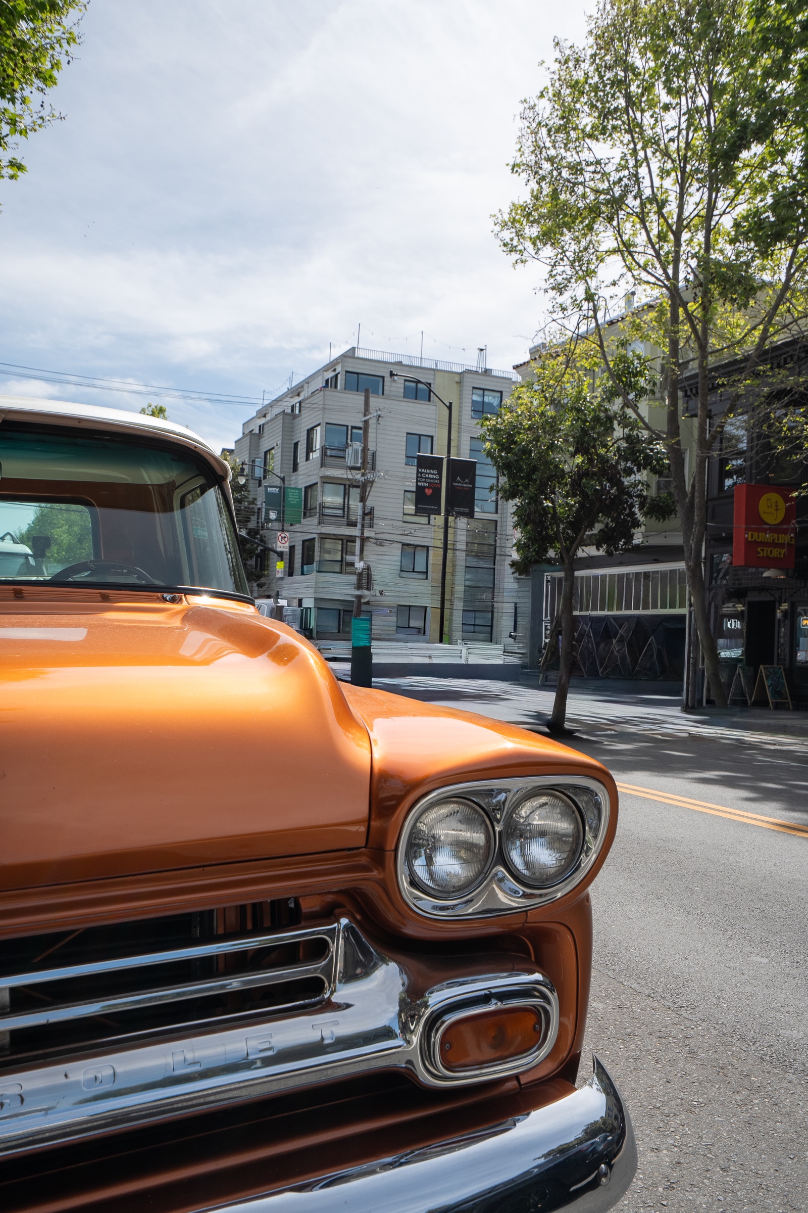 Close architectural view of the chrome headlights and copper bodywork of a classic Chevrolet truck.
