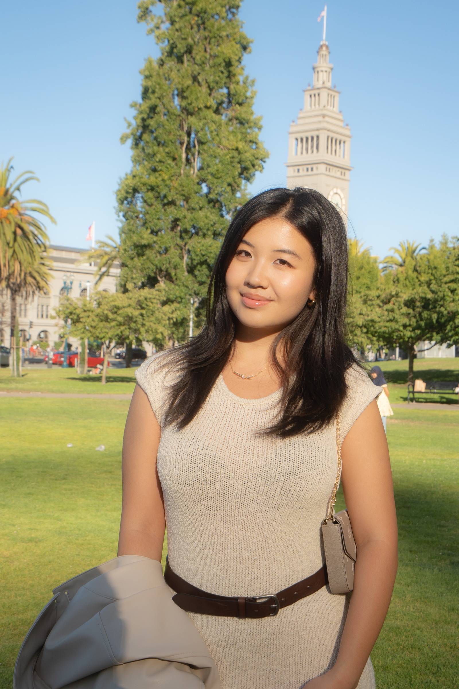 Portrait of a woman in warm afternoon light with the Ferry Building tower behind her.